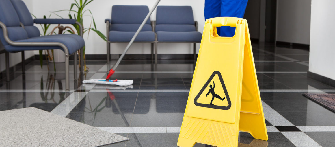 Man With Mop And Wet Floor Sign