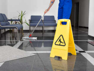 Man With Mop And Wet Floor Sign