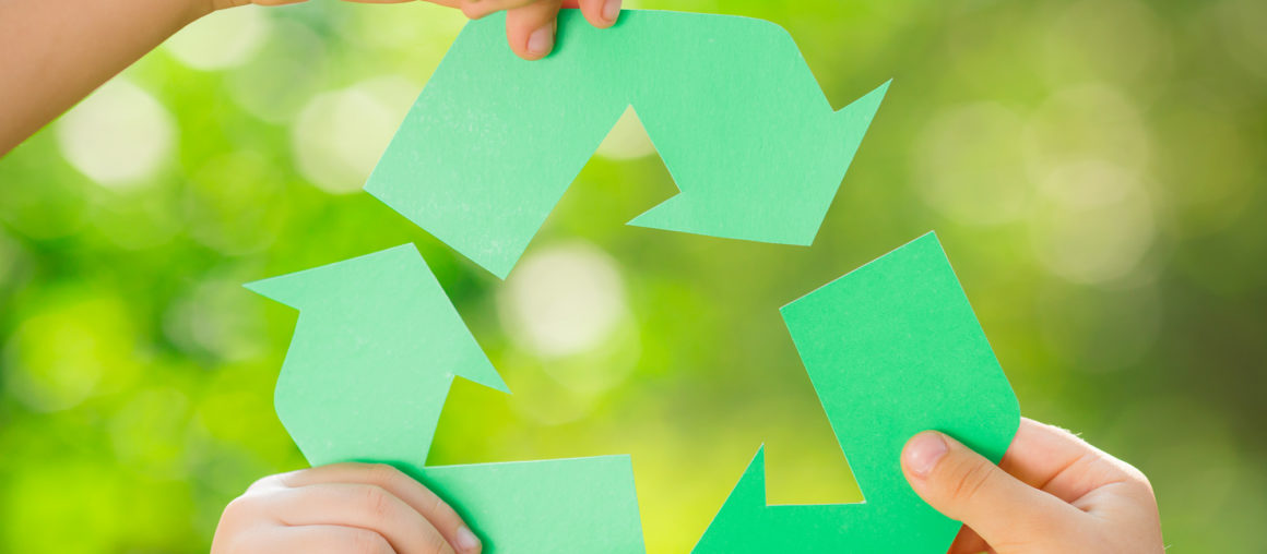 Paper RECYCLE sign in children`s hands