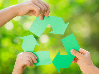 Paper RECYCLE sign in children`s hands