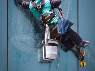 group of workers cleaning windows service on high rise building