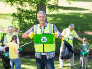 Happy father holding recycling case on a sunny day